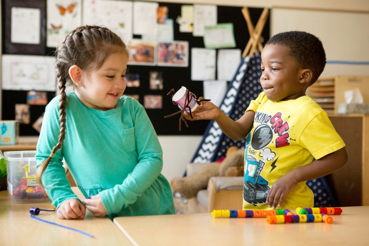 Two students building together with craft materials